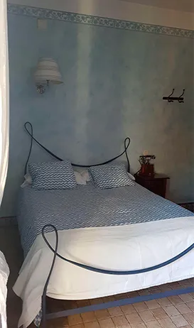 Hostería Natura: habitación doble con cama de forja y paredes azul claro