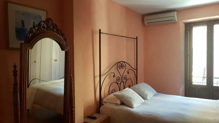 Hostería Natura: habitación doble con cama de forja y espejo de madera